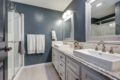 a bathroom with granite counters and gray walls